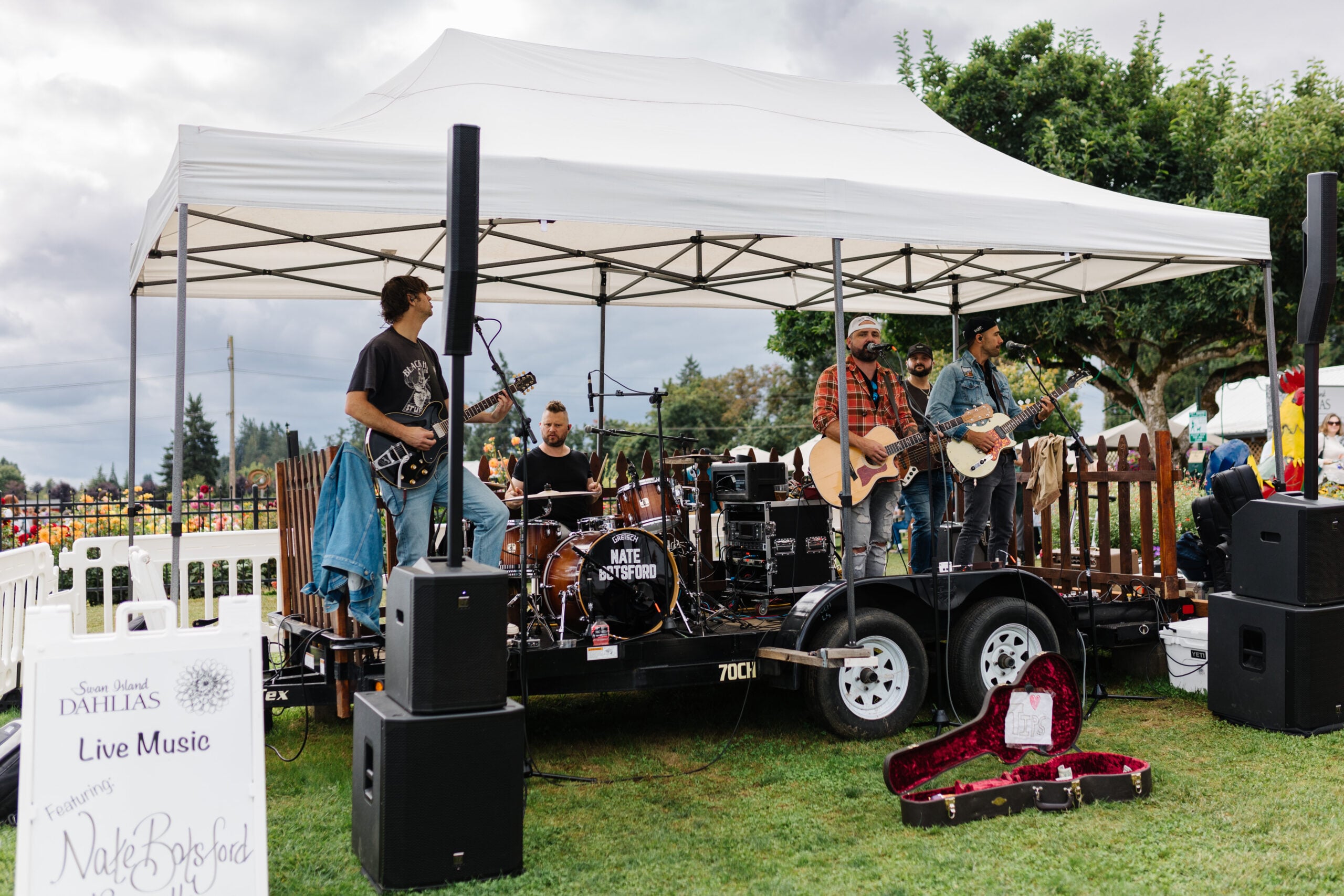 A four-person band plays with a field of pink dahlias in the background